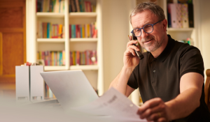 Man on phone reading proposal